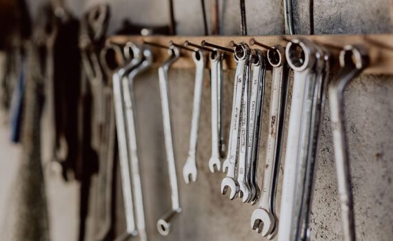 Kiintoavaimia ja muita työkaluja roikkuu nauloista korjaamon seinällä.