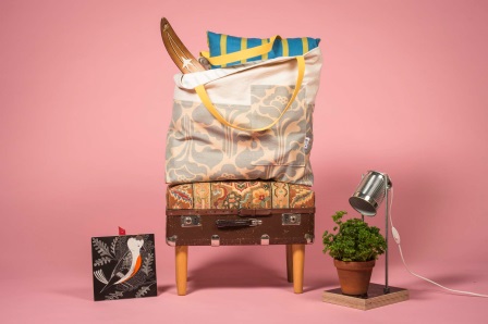Photograph of a lamp, a plant pot, an armchair made of an old suitcase and bags of miscellaneous goods that could potentially be sold at a reuse centre.