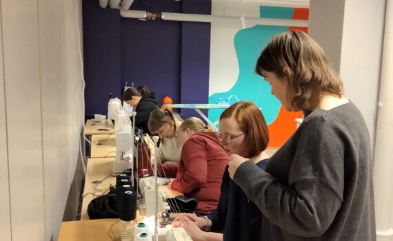 Käsityöpajassa vaatteiden ompelua ompelukoneilla.