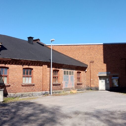 Varaosapankin punatiilinen julkisivu vanhoilla veturitalleilla.