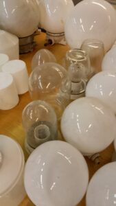 Kirkkaita ja valkoisia pyöreitä lasisia lampun kupuja.