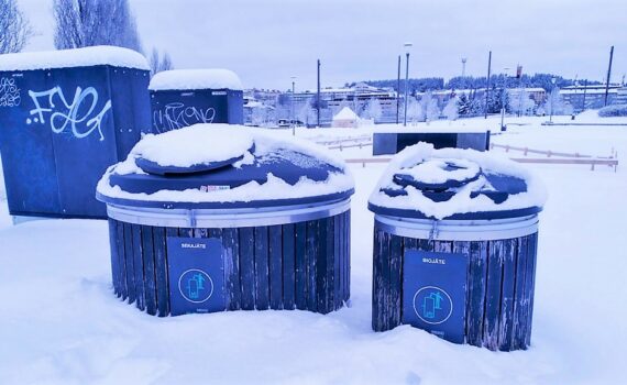 Kuvassa kaksi pyöreää lumen peittämää jätekeräysastiaa
