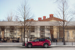 Kuvassa punainen auto kirjaston edessä