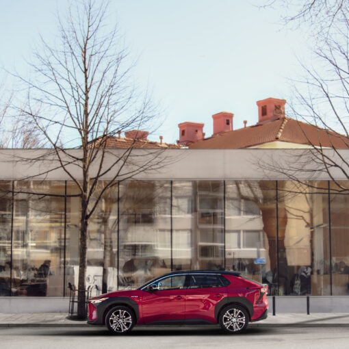 Kuvassa punainen auto kirjaston edessä