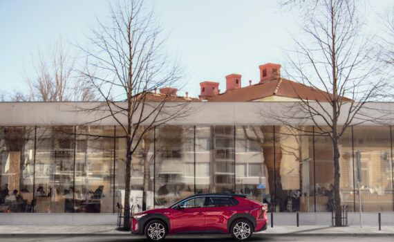 Kuvassa punainen auto kirjaston edessä