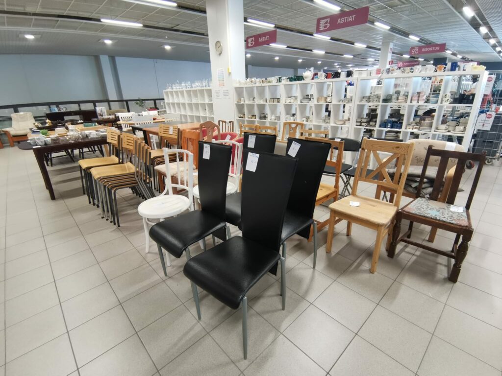 KERKKÄ myymälä: myynnissä olevia tuoleja rivissä. Taustalla näkyy hyllykkö, jossa on myynnissä astioita.