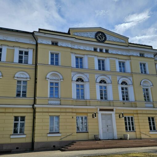 Kuva Eurajoella sijaitsevan Vuojoen kartanon 1836 rakennetusta, C.L. Engelin suunnittelemasta päärakennuksesta. Kartano on keltainen ja kolmikerroksinen. Ikkunanpielet ovat valkoiset.