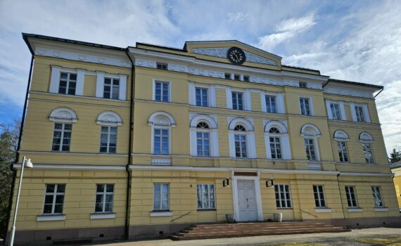 Kuva Eurajoella sijaitsevan Vuojoen kartanon 1836 rakennetusta, C.L. Engelin suunnittelemasta päärakennuksesta. Kartano on keltainen ja kolmikerroksinen. Ikkunanpielet ovat valkoiset.