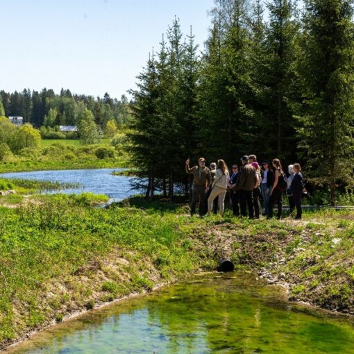 Ryhmä ihmisiä kulkemassa kahden vesialtaan erottavan maamassan yli.