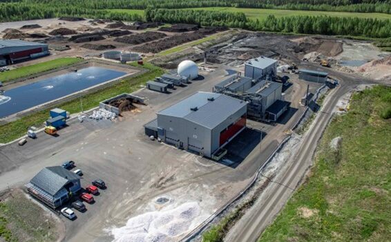 Ilmakuva Kukkuroinmäen jätekeskuksen alueesta, jossa näkyy rakennuksia, valkoinen pyöreä biokaasusäiliö, läjityskasoja ja taustalla metsää.