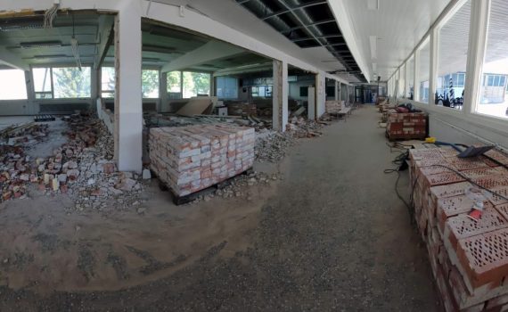 Punaisia purkutiiliä pinoissa rakennuksen sisätilassa.