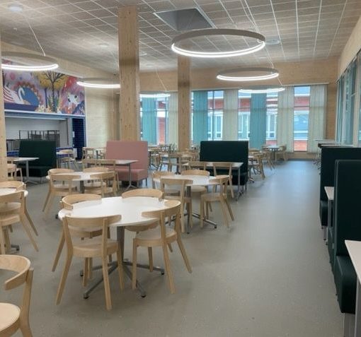 Joutsenon koululla puurakenteet näkyvät myös sisätiloissa. Puu näkyy sisäseinissä, pylväissä ja pöytäryhmien tuoleissa.